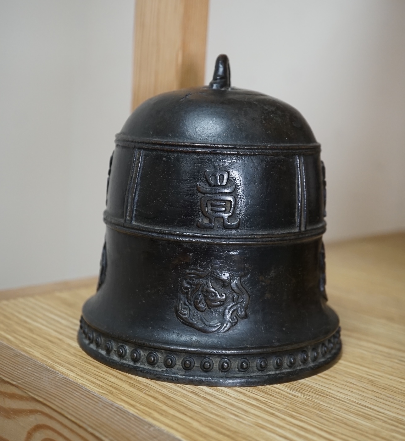 A Chinese archaistic bronze bell, two bronze mirrors, a bronze figure of Nandi, a kitchen Qing dish, and a Japanese antimony vase, largest 27cm in diameter. Condition - mostly fair